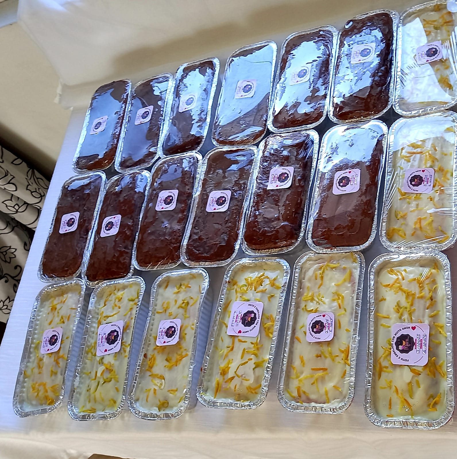 Bandejas com bolos e cuques caseiros embalados em formas de alumínio