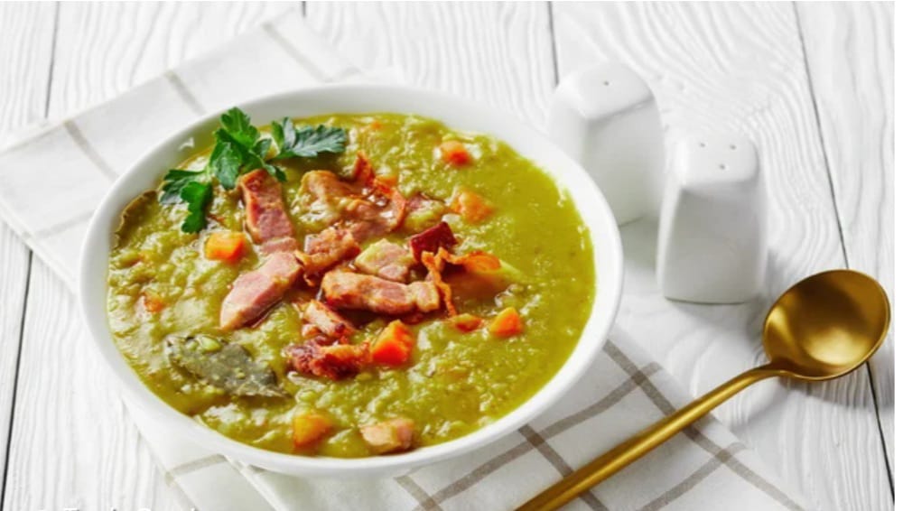 Caldo verde cremoso em tigela branca com bacon e cenoura